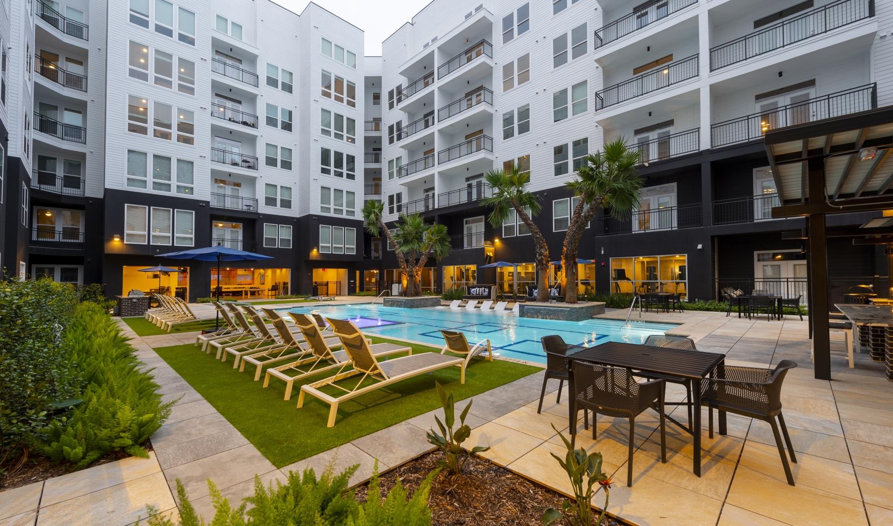 a pool with chairs and tables next to it